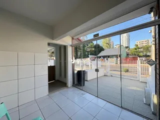 Interior com piso de cerâmica e porta de vidro abrindo para uma área externa.