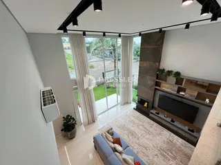 Sala de estar com portas de vidro que dão acesso a um jardim.
