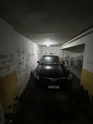Hall de entrada com paredes desgastadas e carro estacionado