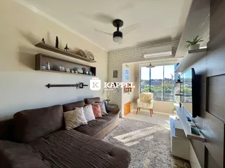 A sala de estar apresenta um sofá grande e decoração com prateleiras na parede.