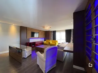Sala de estar moderna com piso de madeira e sofá amarelo.