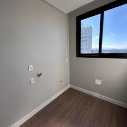 Parede interna com uma grande janela de esquadria preta.