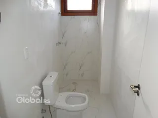 Foto interna de um banheiro com revestimento em mármore branco.