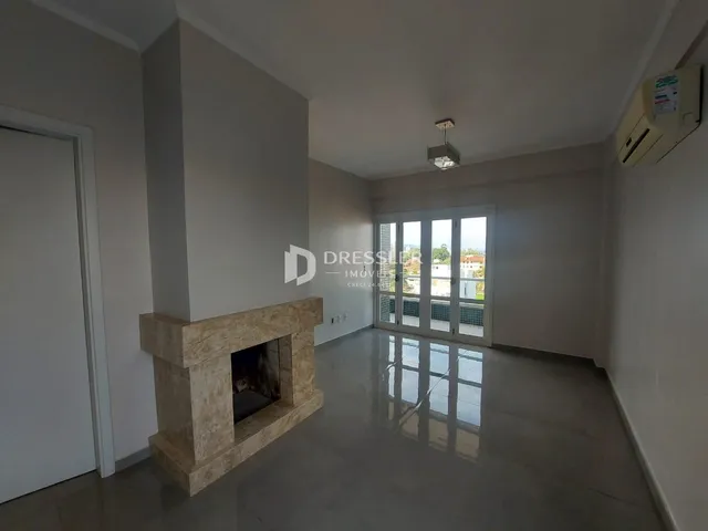 A sala de estar apresenta uma parede com lareira de pedra e portas de vidro.