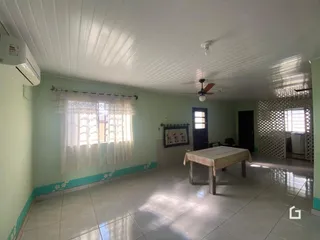 Vista interna de um corredor com paredes verdes e piso de cerâmica.