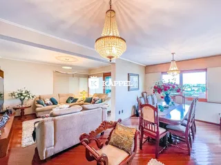 Sala de estar com sofá e mesa de jantar em ambiente bem iluminado.