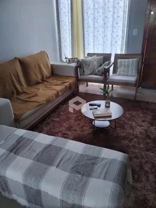 Sala de estar com sofá e tapete em ambiente interno.