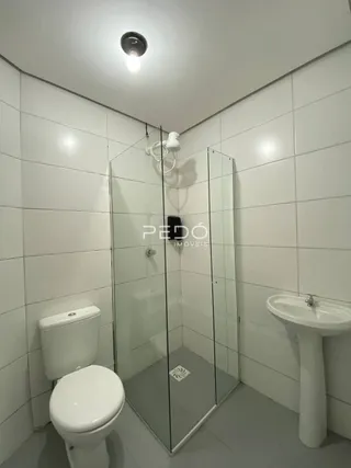 A foto mostra o interior de um banheiro com azulejos brancos.