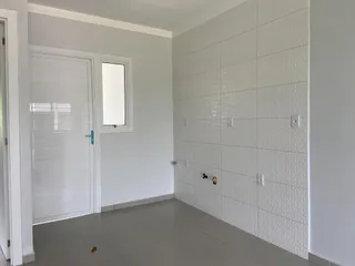 Hall de entrada com porta branca e parede revestida de ladrilhos brancos.