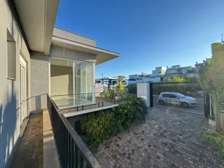 Fachada de uma residência em Lajeado, Brasil, com porta de vidro e área externa cercada por grade.