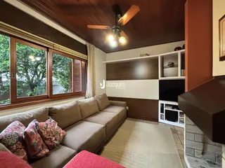 Sala de estar com sofá e grandes janelas em um imóvel no Brasil.