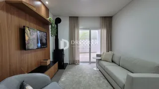 Sala de estar com sofá e televisão em ambiente moderno.
