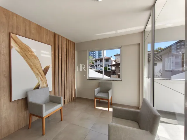 Sala de estar com painéis de madeira e móveis claros.