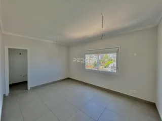 Ambiente interno de uma sala com piso de cerâmica e paredes brancas.