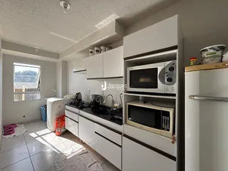 Foto de uma cozinha moderna com armários brancos e bancadas escuras.