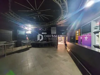 Vista interna de um espaço comercial com teto arquitetônico e área de estar.