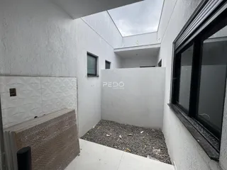 Vista interna de um espaço com teto inclinado e parede de revestimento na Lajeado.