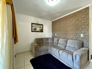 Sala de estar com sofá grande e parede decorada em Lajeado.