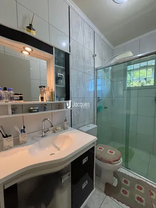 Banheiro com box de vidro e revestimento cerâmico na Lajeado.