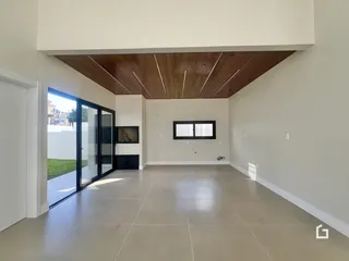 Sala ampla com piso claro e portas de vidro que dão acesso ao exterior.