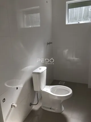Foto interna de um banheiro com vaso sanitário branco.