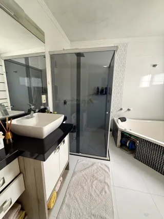 Vista de um banheiro com box de vidro e banheira em um imóvel no Brasil.