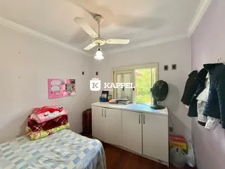 Quarto com cama e armário branco em ambiente interno.