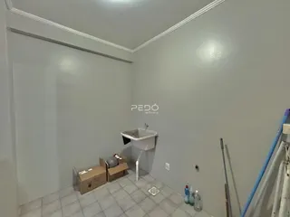 Interior de um cômodo com paredes cinzas e piso de cerâmica.
