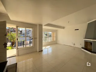 Ambiente interno de uma sala ampla com piso de cerâmica clara.