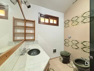 Foto do interior de um banheiro com revestimento de azulejos decorativos.