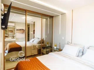 Quarto com cama de casal e espelho grande em um apartamento.