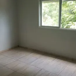 Vista do piso de uma área interna com revestimento de cerâmica clara.