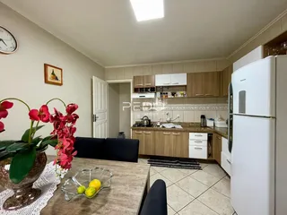 Interior de uma sala de estar com cozinha em um imóvel no Brasil.