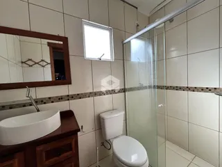 Foto de um banheiro com revestimento de azulejos brancos e box de vidro.