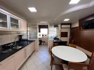 Foto de uma cozinha e sala de jantar com armários e mesa de jantar.