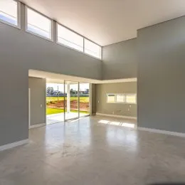 Ambiente interno amplo com grandes portas de vidro que dão acesso a uma área externa.