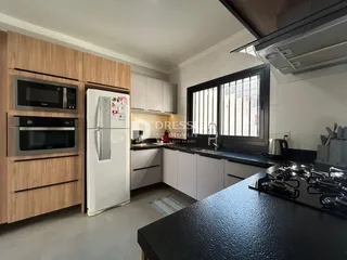 Cozinha moderna com armários de madeira e bancadas escuras.