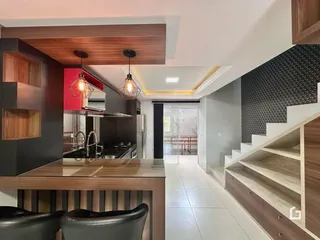 Interior de uma cozinha e sala de estar com escadaria moderna.