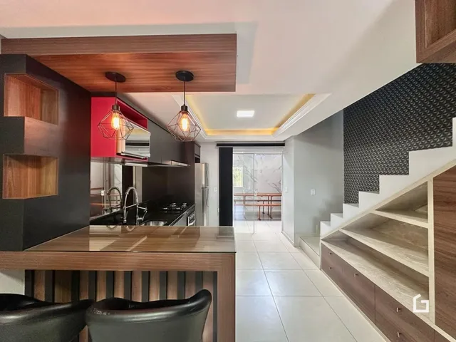 Interior de uma cozinha e sala de estar com escadaria moderna.