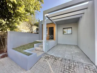Fachada moderna de uma residência com jardim lateral em Lajeado, Brasil.