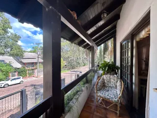 Vista de uma varanda com piso de cerâmica e grade de ferro.