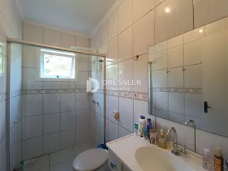 Foto do interior de um banheiro com revestimento cerâmico nas paredes.