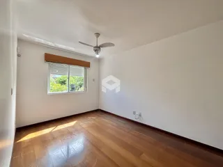 Imagem de uma sala com piso de madeira e janela.