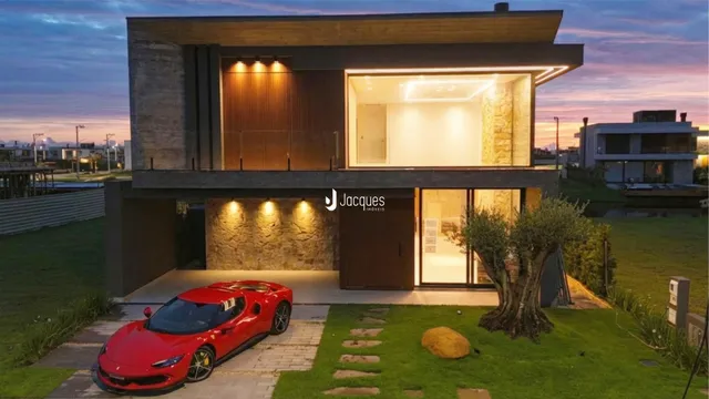 Fachada moderna de uma residência em Lajeado, Brasil, com jardim e carro estacionado.