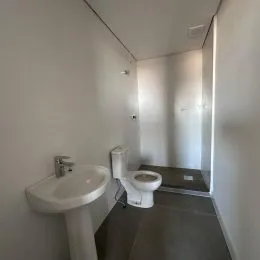 Foto de um lavabo com pias brancas em um ambiente interno.