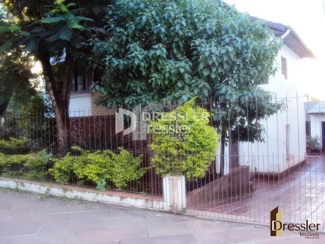 Fachada de uma residência em Lajeado, Brasil, com vegetação e cerca.