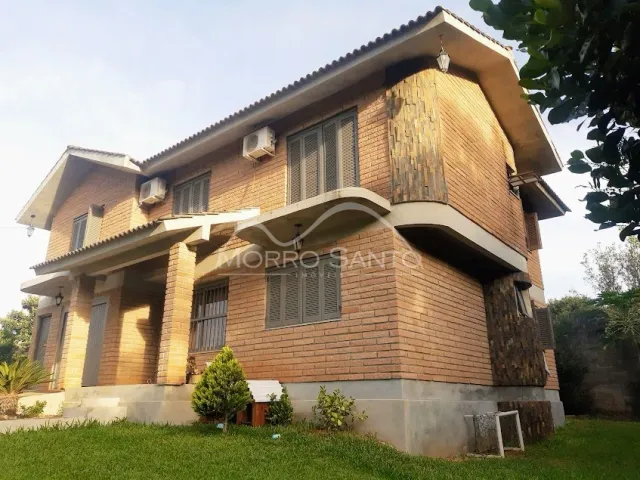 Fachada de uma casa residencial de dois andares em Lajeado, Brasil, com revestimento de tijolos aparentes.