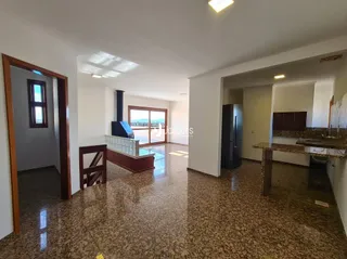 Interior de uma sala com piso de cerâmica e molduras de madeira.