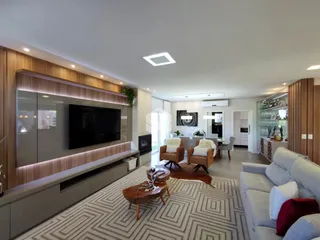 Sala de estar moderna com painel de madeira e televisão.