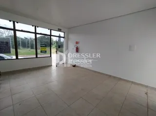 Sala de estar com grandes janelas de vidro em um imóvel no Brasil.